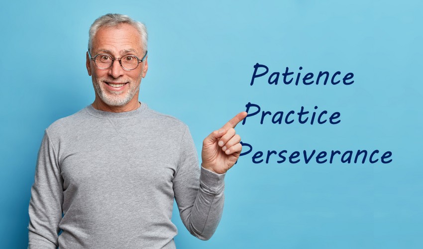 A smiling man pointing to words "patience, practice, perseverance" written in the air beside him, highlighting key strategies for PLAB exam preparation.