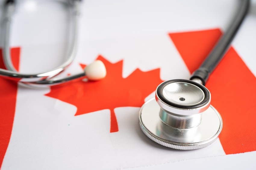 A stethoscope lies on a Canadian flag, symbolizing healthcare in Canada in Is MCCQE part 1 worth taking? blog