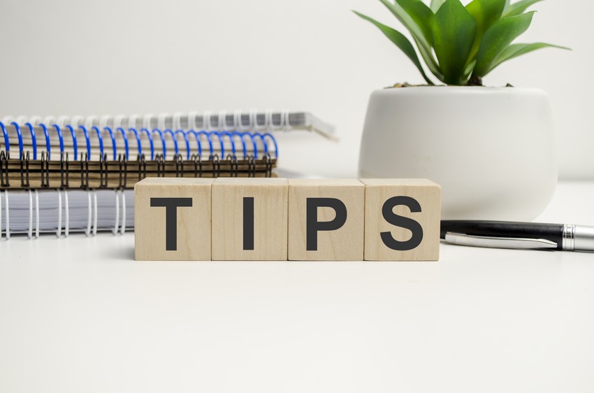 Wooden blocks spelling "TIPS" are displayed on a desk with spiral notebooks, a pen, and a potted plant in the background, offering calming strategies for MCCQE1 exam anxiety.