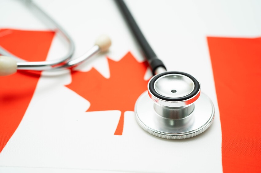A stethoscope rests on a Canadian flag, symbolizing healthcare in Canada and the journey of aspiring doctors preparing for the MCCQE1 exam with Ace QBank and tracking MCCQE1 exam dates