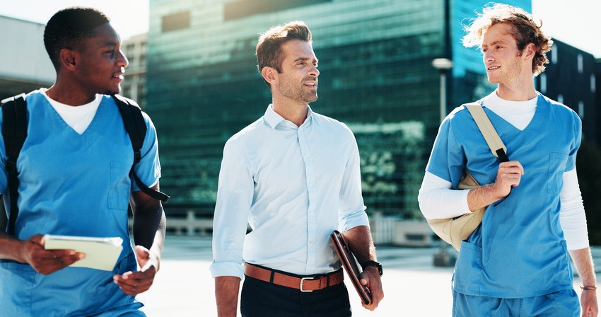 Three men, two in blue scrubs and one in a white dress shirt and dark pants, walk outdoors together carrying bags and documents. Perhaps discussing how to monitor MCCQE1 exam preparation or sharing tips about Ace QBank. All with modern buildings in the background.